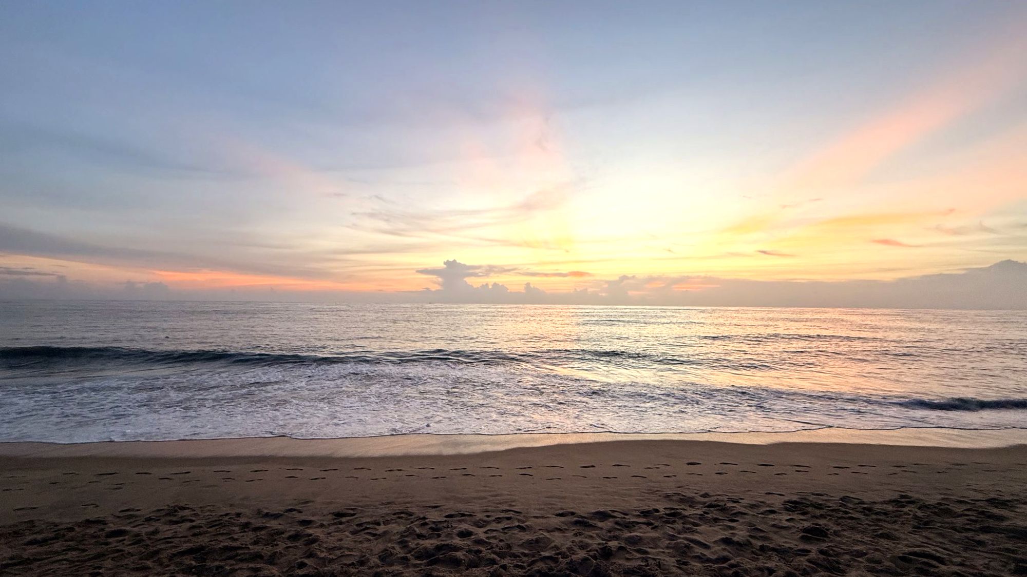 Soft rays of early light over a calm sea