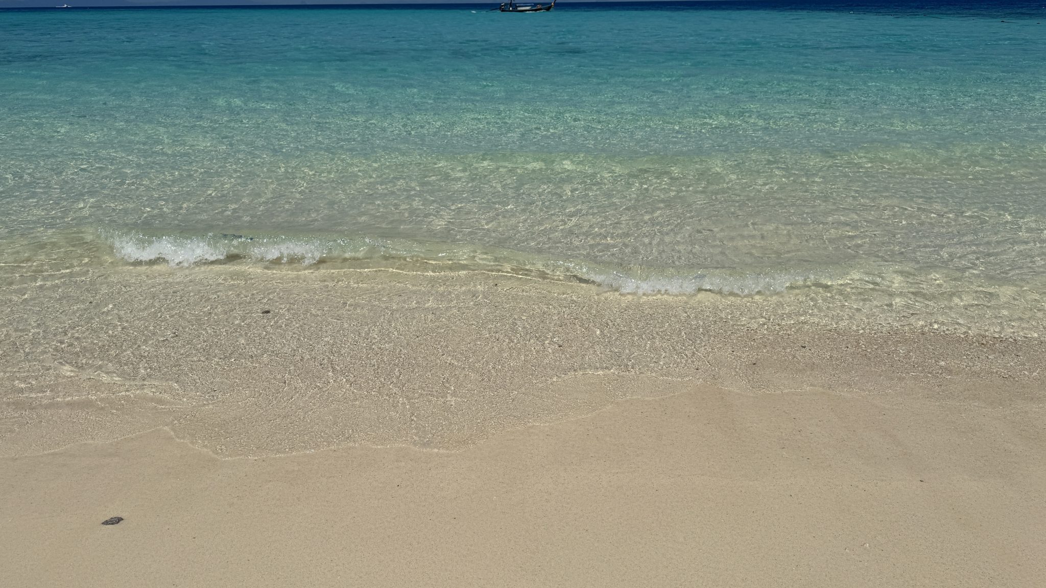 Clear shallow water lapping over pale sand